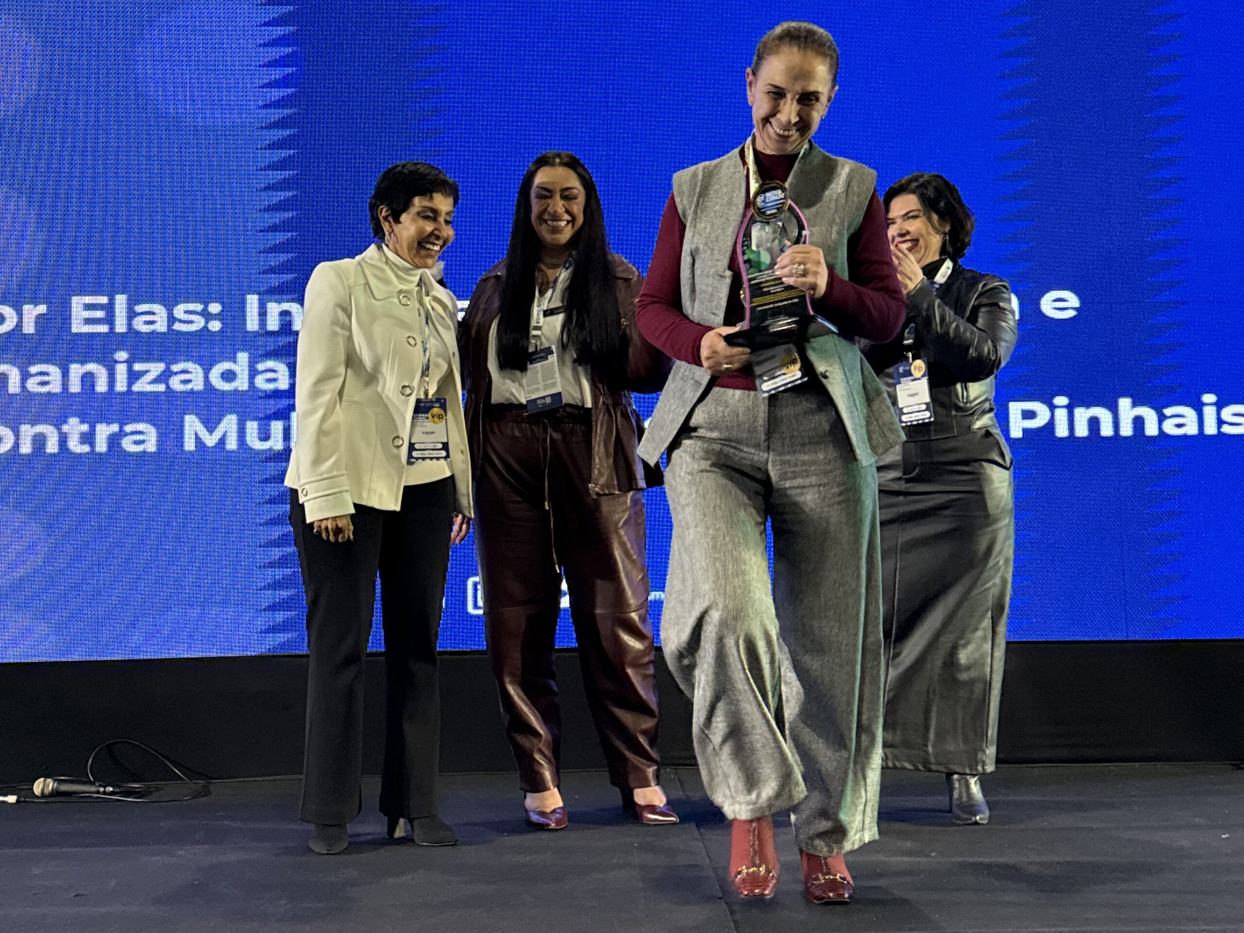 Prefeita Nina Singer sorrindo e segurando o Prêmio InovaCidade – Liderança Feminina durante o Smart City Expo Curitiba.